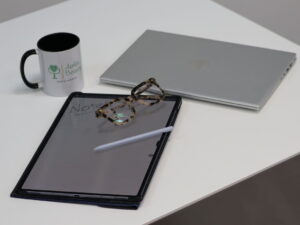 Tablet, laptop and Awlin Beauty branded mug on a white desk for the clinic blog header image